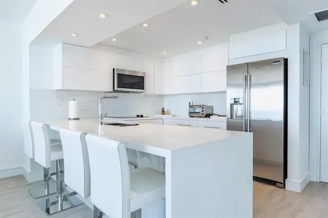 a kitchen with stainless steel appliances a refrigerator and a stove top oven