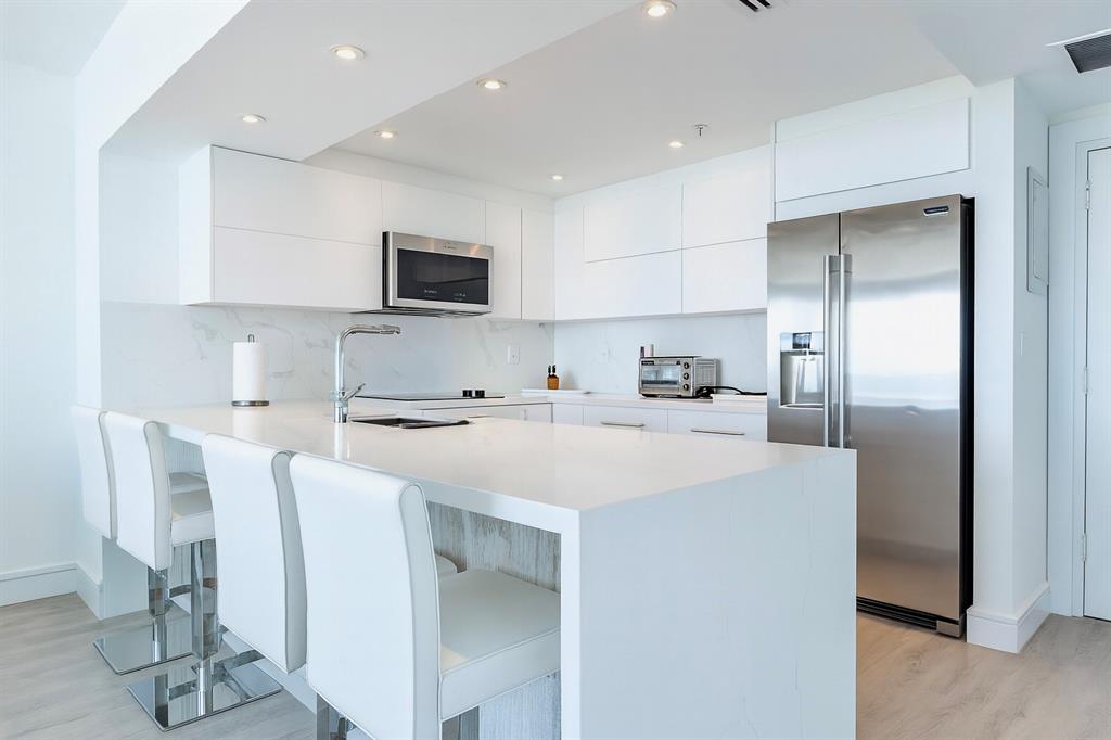 a kitchen with stainless steel appliances a refrigerator and a stove top oven