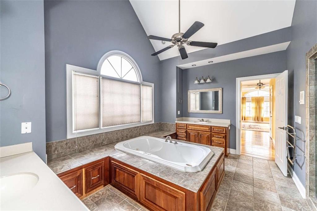 4 Bridgeview Drive Southeast Rome, GA 30161 - Photo 19 of 42 a bathroom with a granite countertop tub a sink and a large mirror