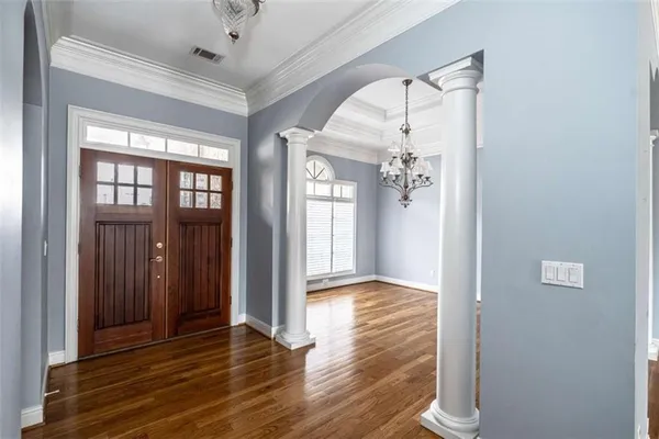 a view of a hallway with wooden floor and a bathroom