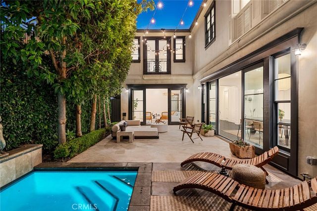 a view of a patio with couches table and chairs and potted plants