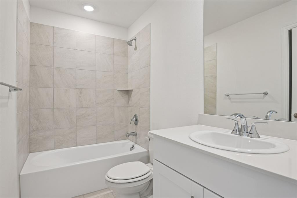 2203 Rannoch Street Sherman, TX 75092 - Photo 18 of 37 a bathroom with a bathtub shower sink vanity mirror and toilet