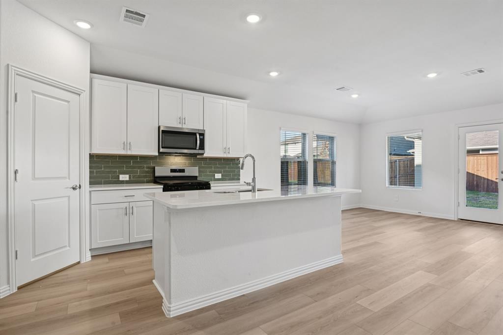 2203 Rannoch Street Sherman, TX 75092 - Photo 3 of 37 a kitchen with granite countertop a stove a sink and a refrigerator