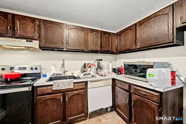 a kitchen with granite countertop a sink cabinets and stainless steel appliances
