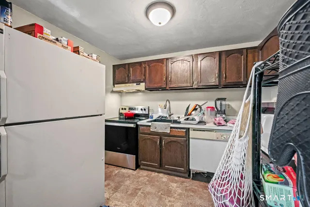 a kitchen with stainless steel appliances granite countertop a refrigerator and a sink