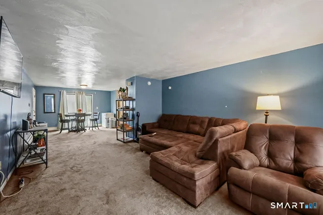 a living room with furniture and a dining table with window