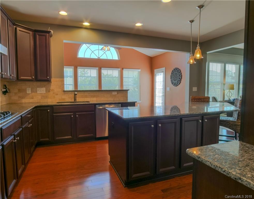 1621 Ridgehaven Road Waxhaw, NC 28173 - Photo 11 of 36 a kitchen with stainless steel appliances granite countertop wooden cabinets a stove a sink and a large window