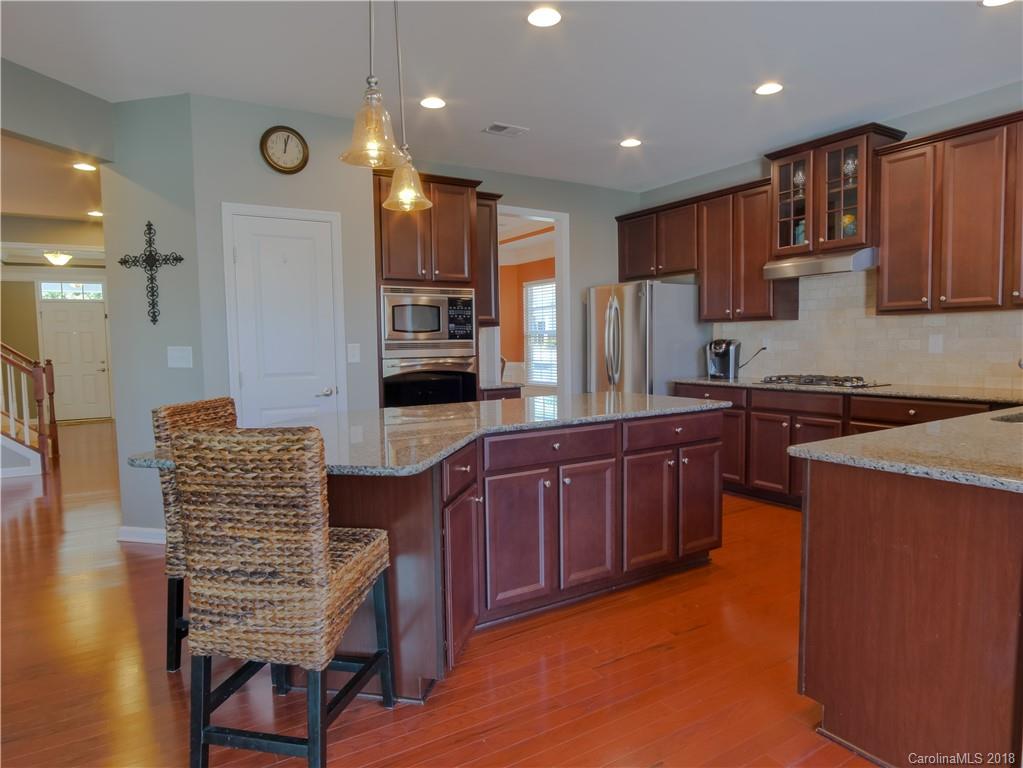 1621 Ridgehaven Road Waxhaw, NC 28173 - Photo 12 of 36 a kitchen with stainless steel appliances granite countertop wooden cabinets a stove top oven a sink and dishwasher