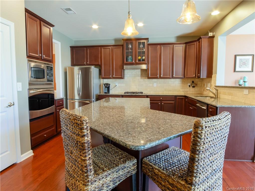 1621 Ridgehaven Road Waxhaw, NC 28173 - Photo 13 of 36 a kitchen with granite countertop a table chairs stainless steel appliances and cabinets