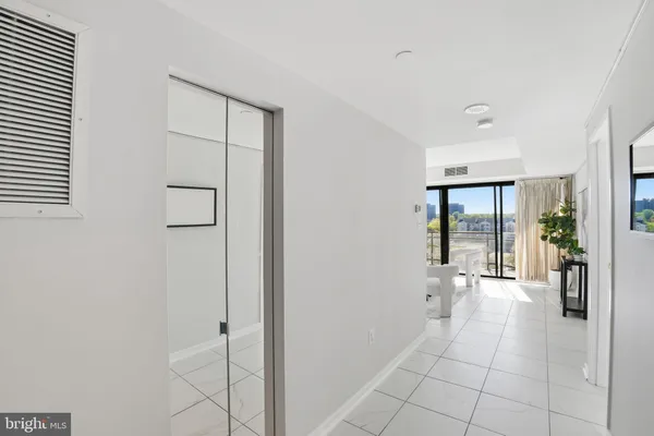 a hallway with sliding door and natural light