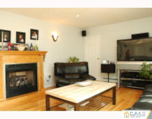 52 Eardley Road Edison, NJ 08817 - Photo 4 of 10 a living room with furniture a flat screen tv and a fireplace