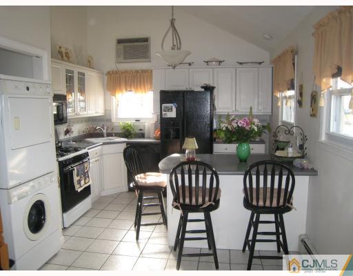 52 Eardley Road Edison, NJ 08817 - Photo 7 of 10 a kitchen with stainless steel appliances a dining table chairs and a refrigerator