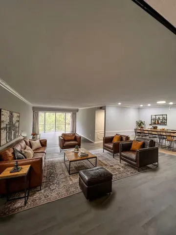 a living room with furniture kitchen view and a window