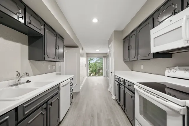 a kitchen with a sink stove and cabinets