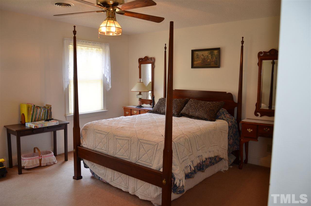 1000 Fate Washington Road Stem, NC 27581 - Photo 22 of 28 a bedroom with a bed and a chandelier