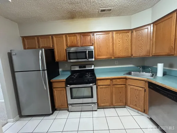 a kitchen with granite countertop a refrigerator and a sink
