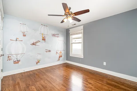 a view of a livingroom with wooden floor and a ceiling fan