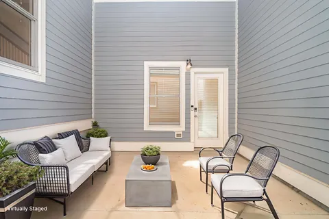 a balcony with couches and a potted plant