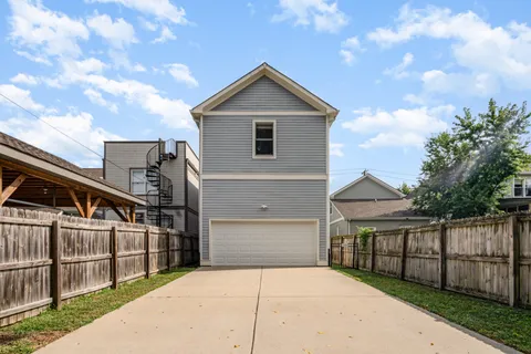 a front view of house with yard and trees in the background