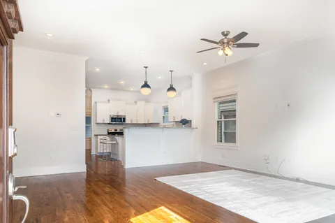 a open kitchen with white cabinets and wooden floor