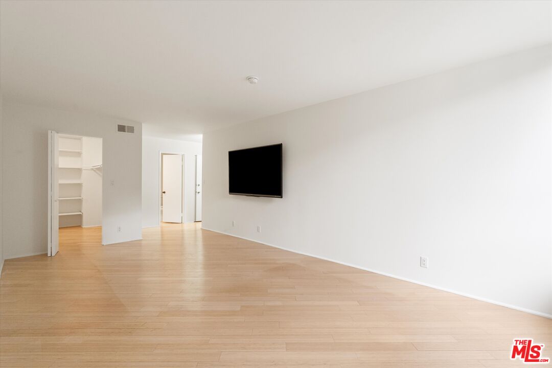 429 North Oakhurst Drive, Unit 203 Beverly Hills, CA 90210 - Photo 16 of 20 a view of an empty room with wooden floor and a flat screen tv