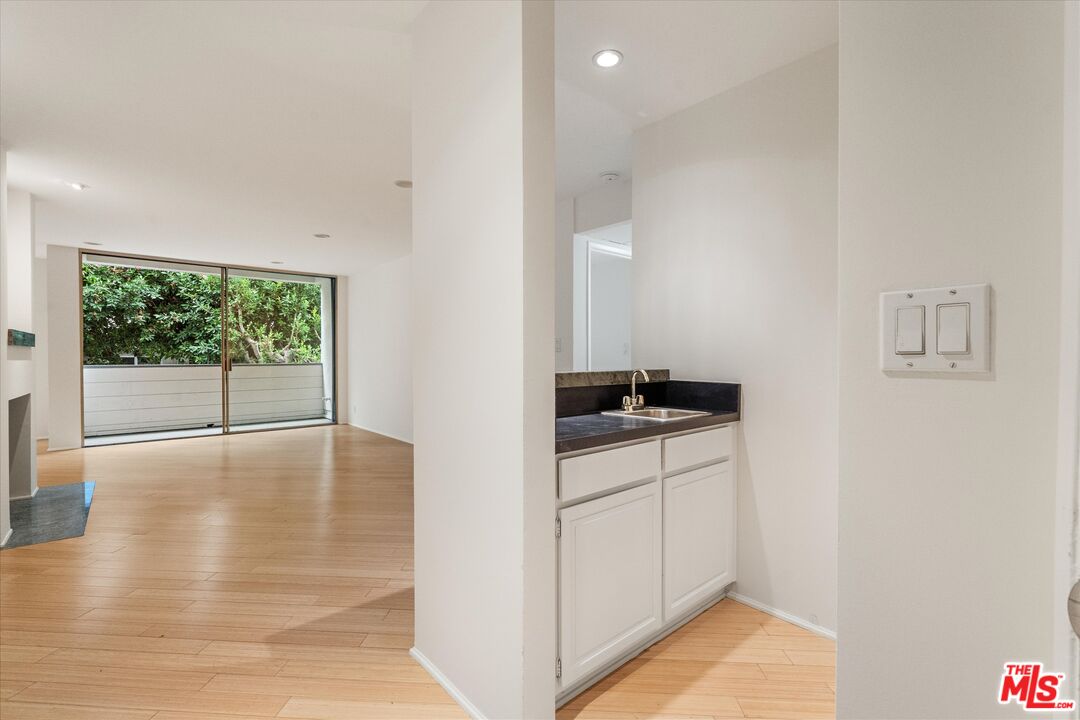 429 North Oakhurst Drive, Unit 203 Beverly Hills, CA 90210 - Photo 3 of 20 a view of a kitchen with a sink and dishwasher with wooden floor