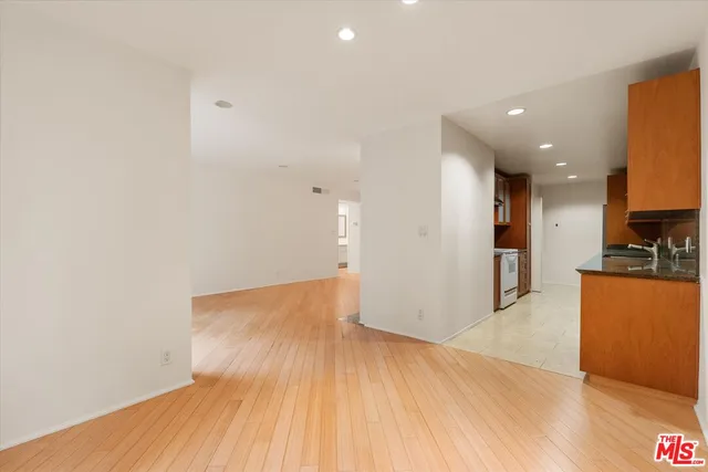 a view of kitchen with refrigerator and wooden floor