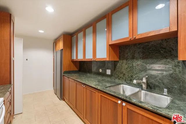 a kitchen with granite countertop a sink and a wooden cabinets