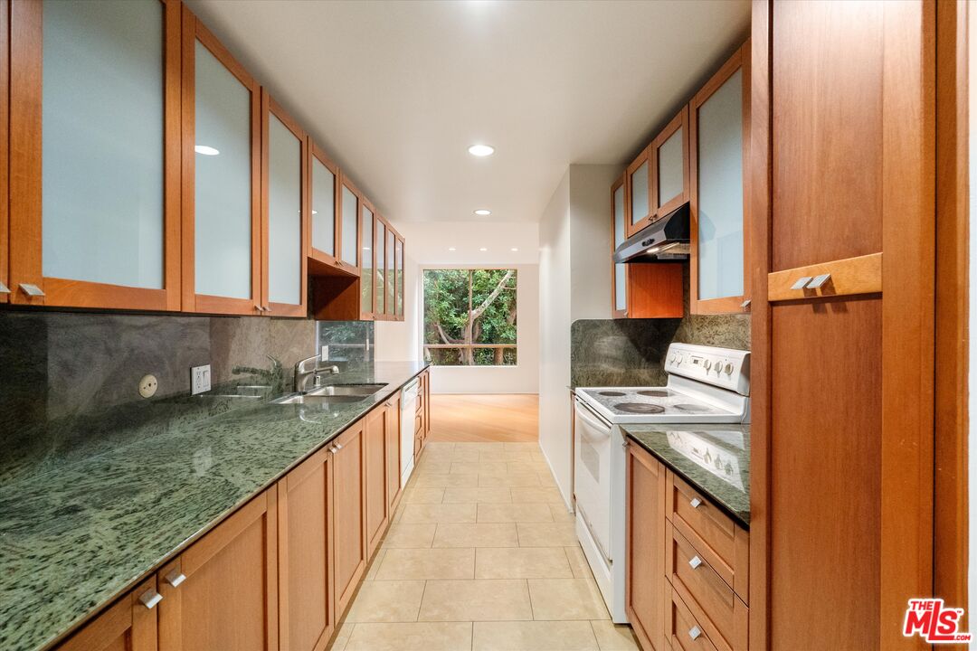 429 North Oakhurst Drive, Unit 203 Beverly Hills, CA 90210 - Photo 9 of 20 a kitchen with stainless steel appliances granite countertop a stove and a sink