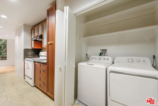 a view of washer and dryer with kitchen in the background