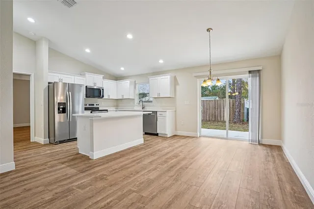 a kitchen with stainless steel appliances a refrigerator and wooden floor