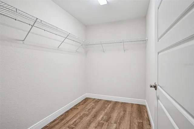 an empty room with a window and a ceiling fan