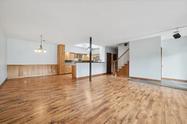 a view of a kitchen with wooden floor and a refrigerator