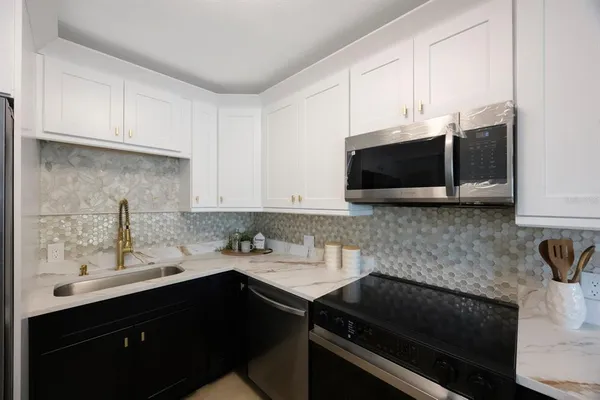 a kitchen with stainless steel appliances a sink dishwasher a stove microwave and cabinets