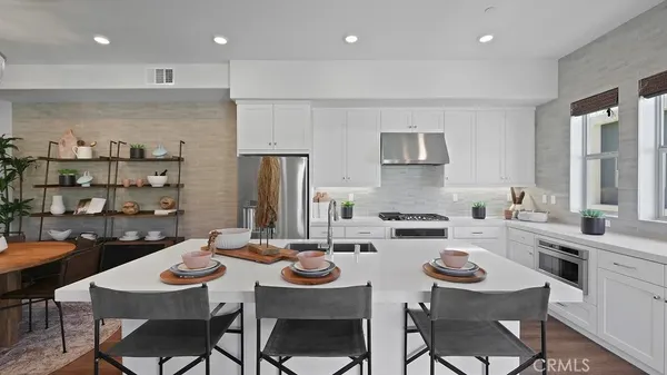 a kitchen with a dining table cabinets and chairs