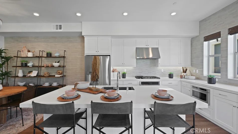 a kitchen with a dining table cabinets and chairs
