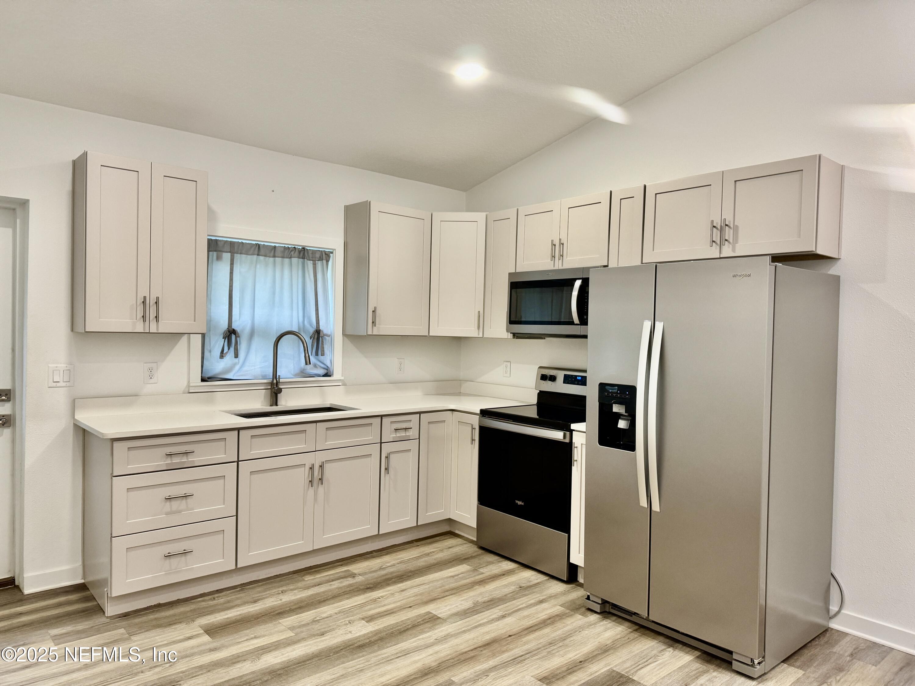 302 Azealea Avenue Interlachen, FL 32148 - Photo 18 of 38 a kitchen with stainless steel appliances granite countertop a refrigerator sink and white cabinets