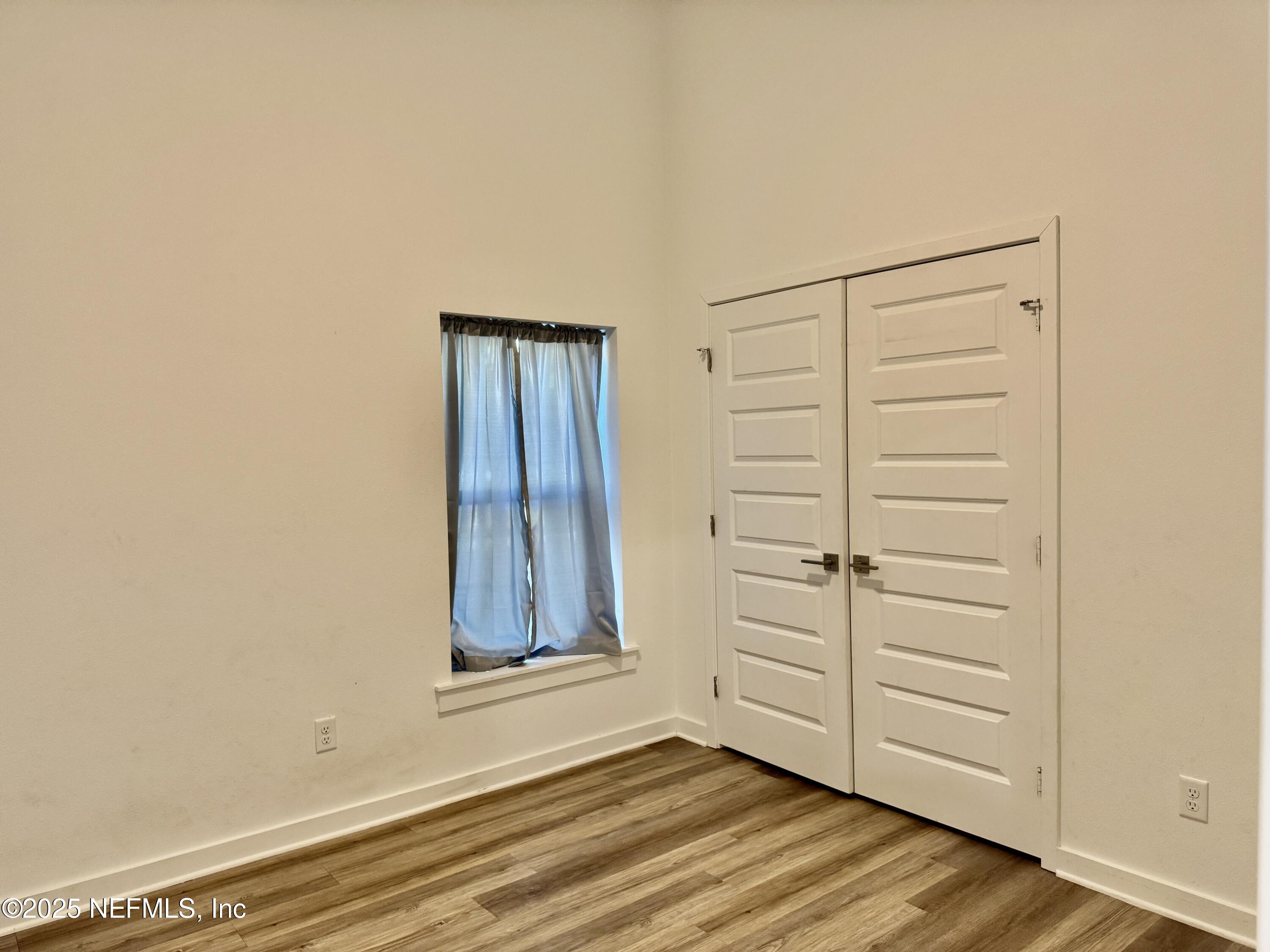 302 Azealea Avenue Interlachen, FL 32148 - Photo 21 of 38 an empty room with wooden floor closet and windows