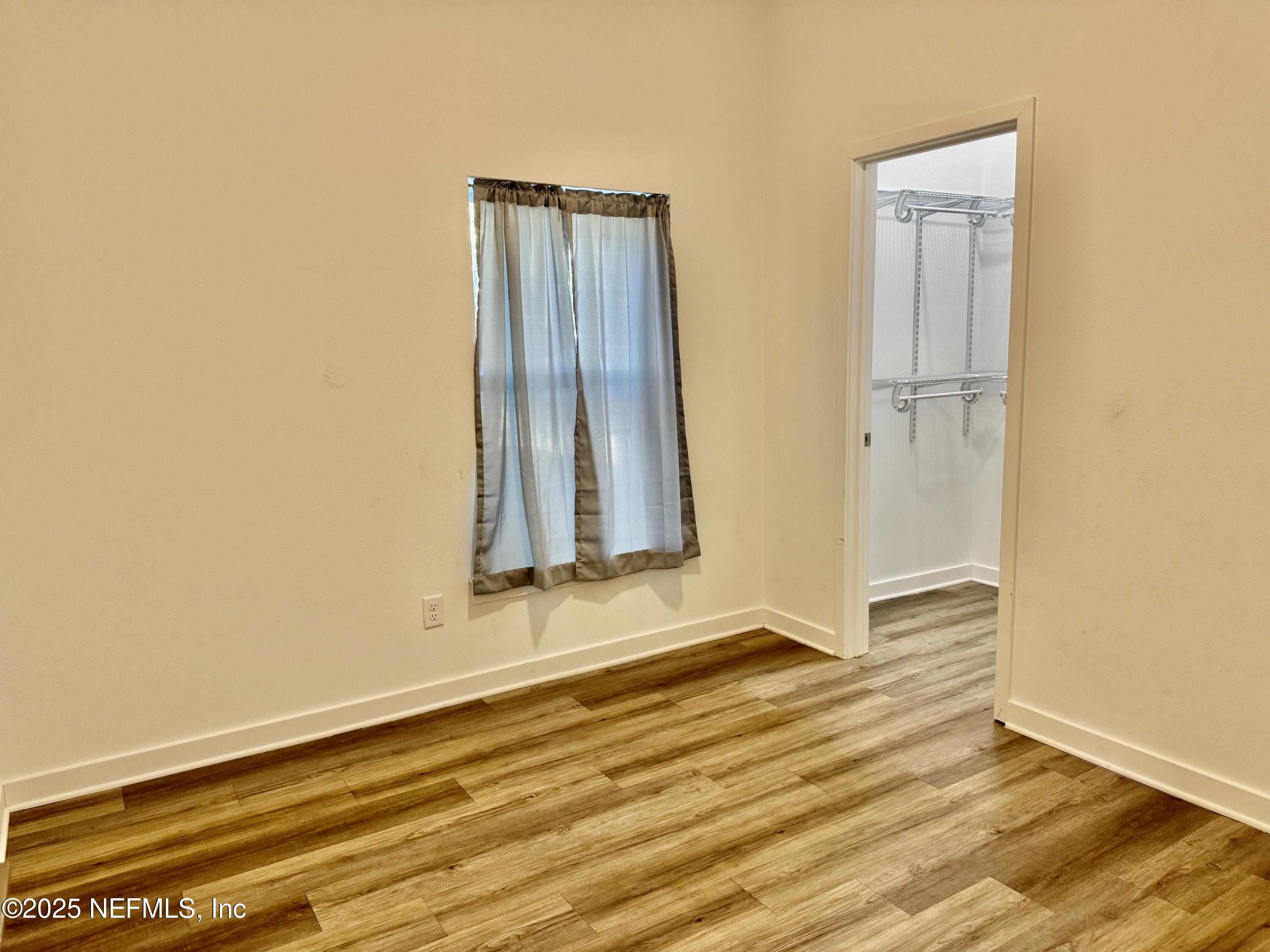 302 Azealea Avenue Interlachen, FL 32148 - Photo 25 of 38 an empty room with wooden floor and a window