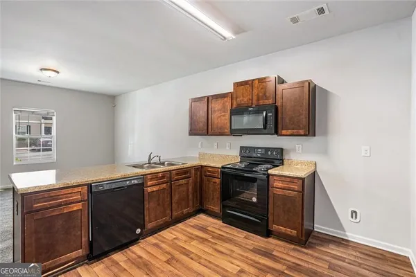 a kitchen with stainless steel appliances granite countertop a sink stove and microwave