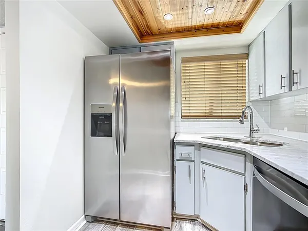 a kitchen with stainless steel appliances granite countertop a sink and a refrigerator