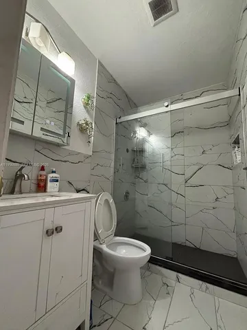 a bathroom with a toilet sink and shower