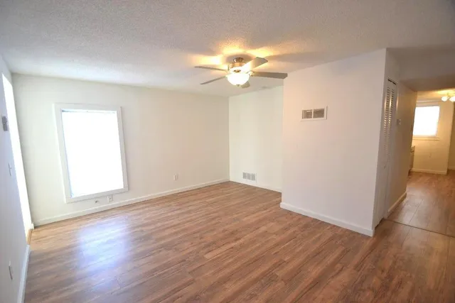 a view of empty room with wooden floor