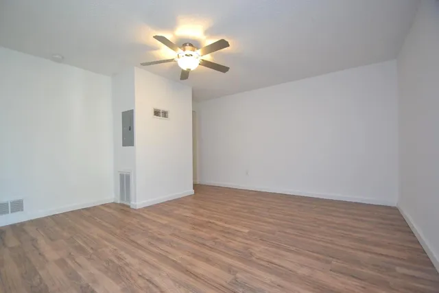 a view of an empty room with wooden floor