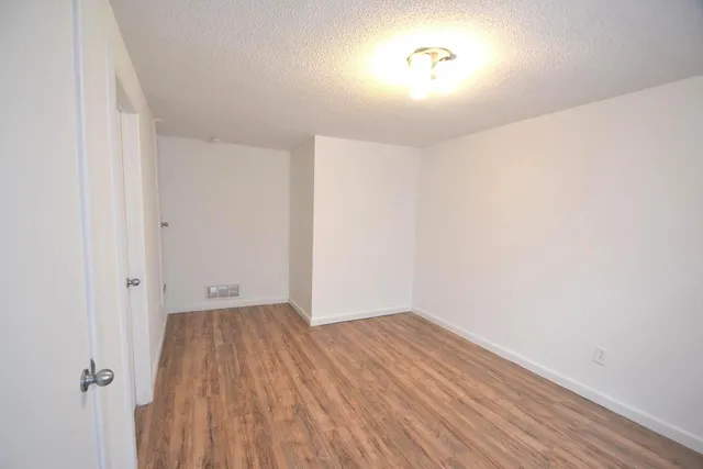a view of a room with wooden floor