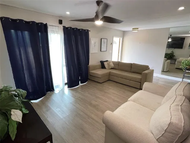 a living room with furniture and a wooden floor
