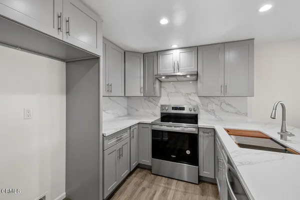 a kitchen with a stove sink and cabinets