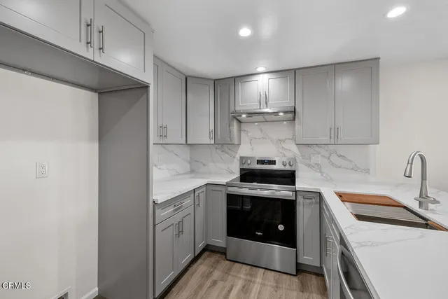 a kitchen with a stove sink and cabinets