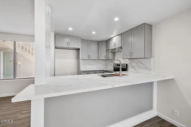 a kitchen with stainless steel appliances a sink stove and refrigerator