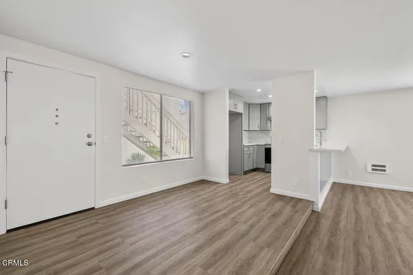 a view of empty room with wooden floor and window